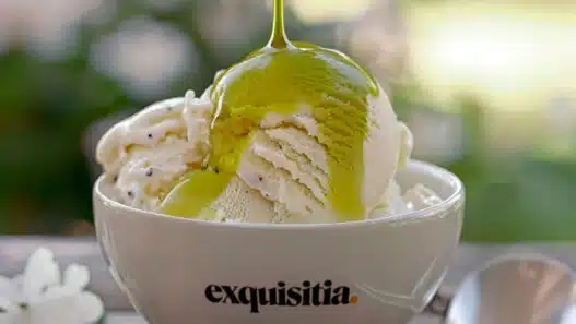 Helado de vainilla con aceite de oliva virgen extra premium Exquisitia cayendo por encima, servido en bol blanco