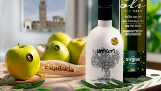 Bodegón gourmet de Exquisitia con lo mejor de Lleida fruta ecológica y botellas de aceite de oliva virgen extra gourmet Umami y Seleqtium, con la Seu Vella al fondo.