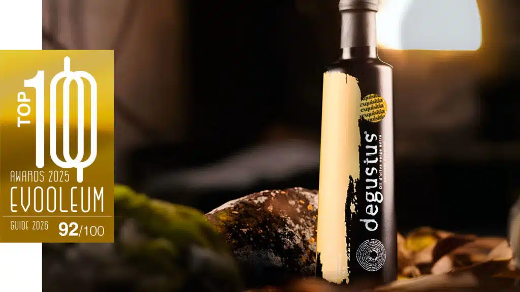 Aceite Degustus Selección Especial premiado con 92 puntos en EVOOLEUM, sobre fondo gourmet con iluminación cálida